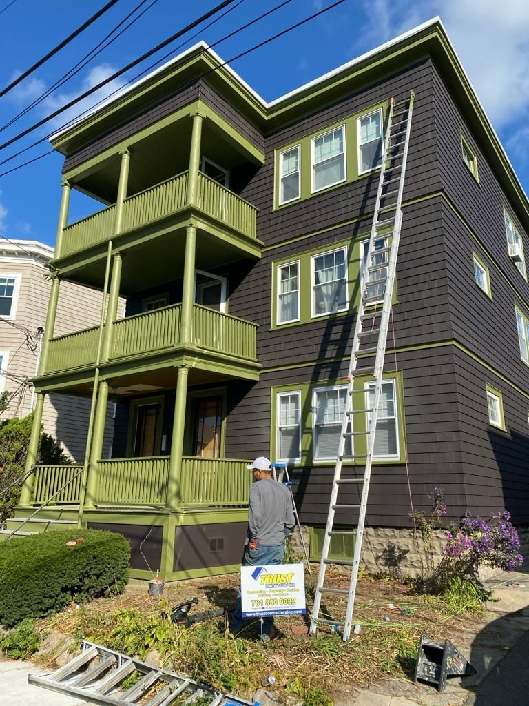 a man is painting the side of a building with a ladder