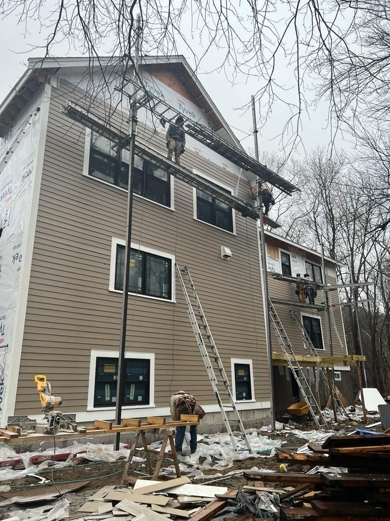 a large house is being remodeled with siding and windows