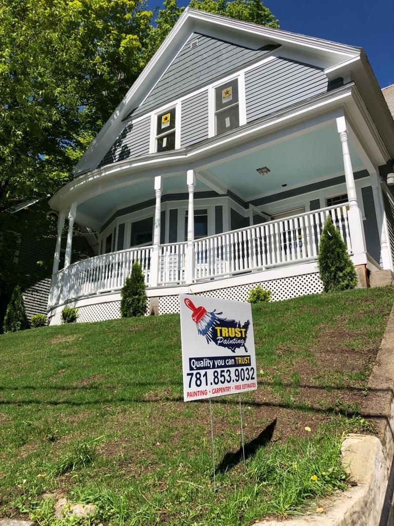a large house with a porch and a for sale sign in front of it