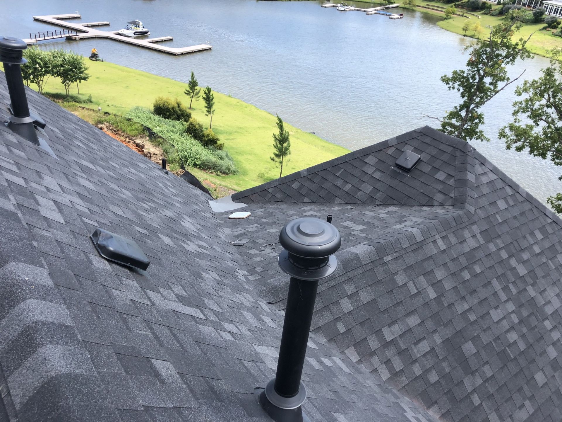The roof of a house with a view of a lake.