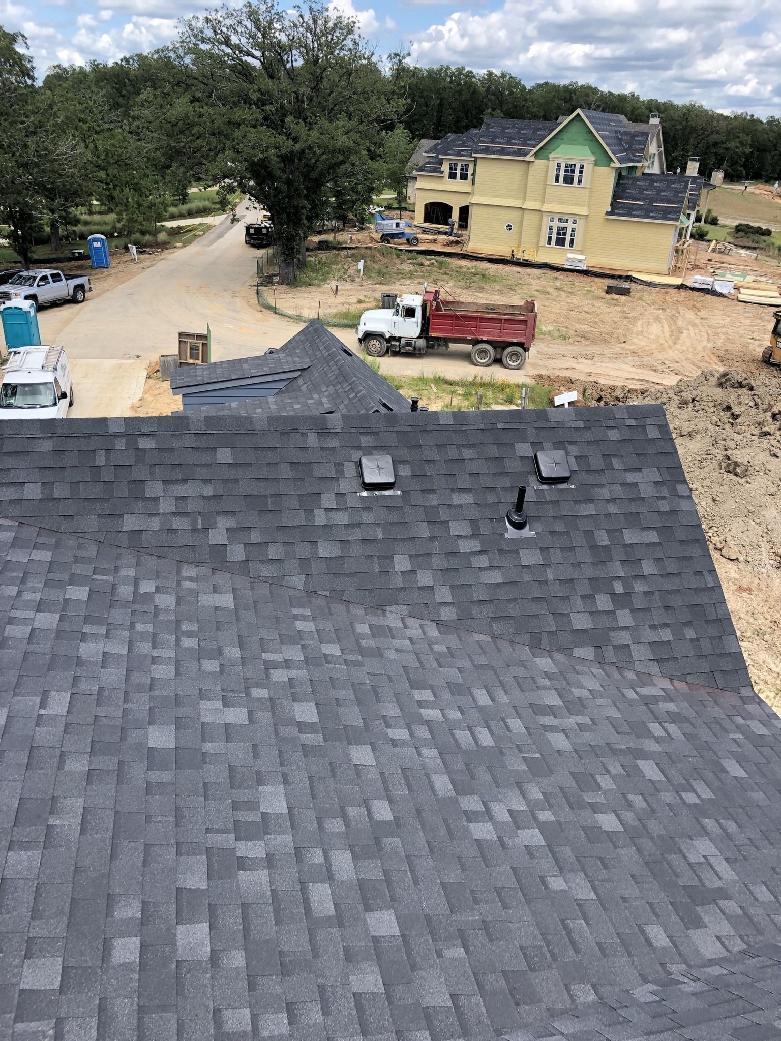 An aerial view of a roof with a dump truck in the background.