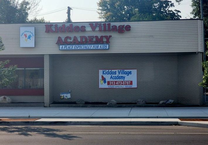A building with a sign on it that says kiddos village academy