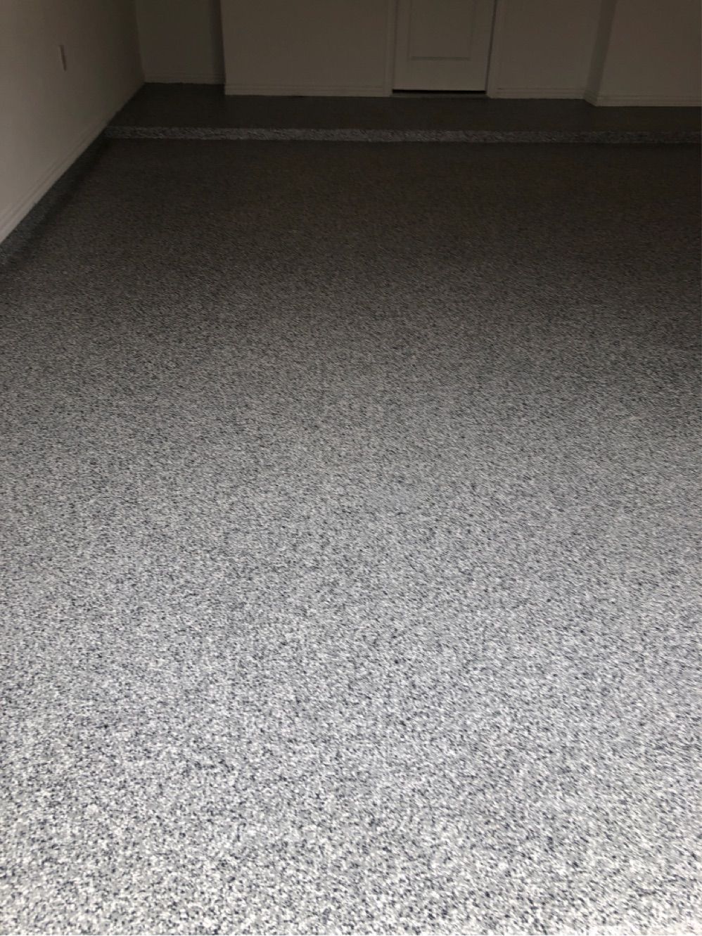 A close up of a gray carpeted floor in a room.