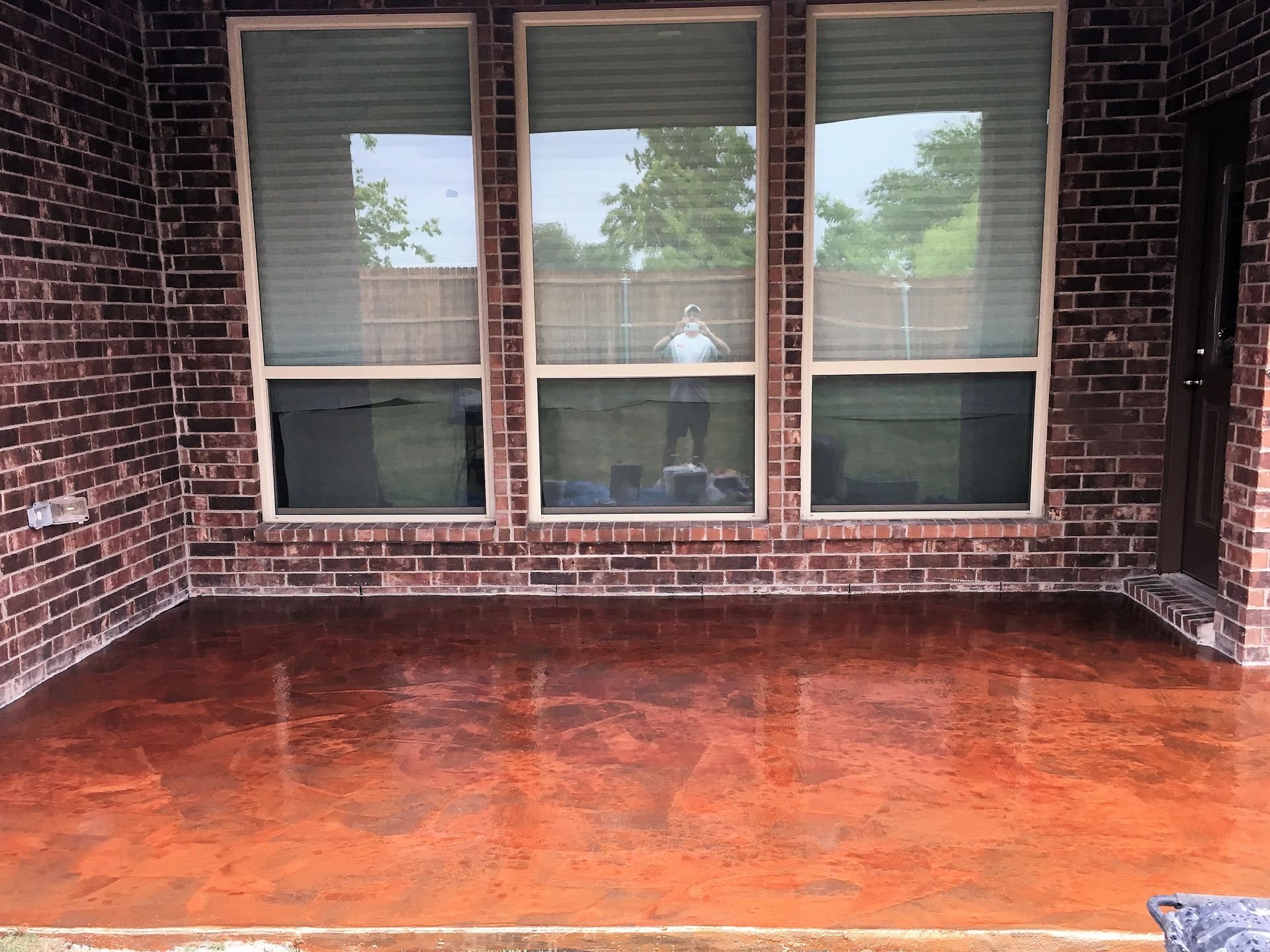 A brick house with a concrete patio in front of it.