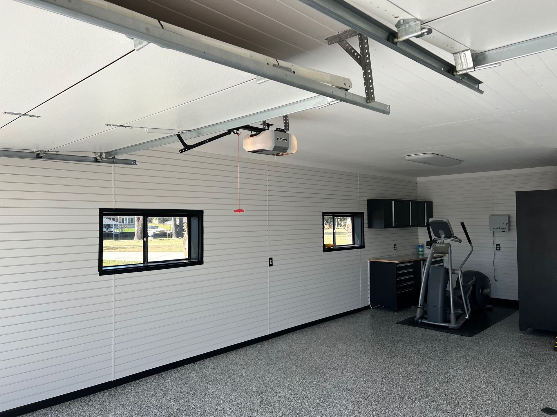 A garage with white walls and a bicycle on the floor