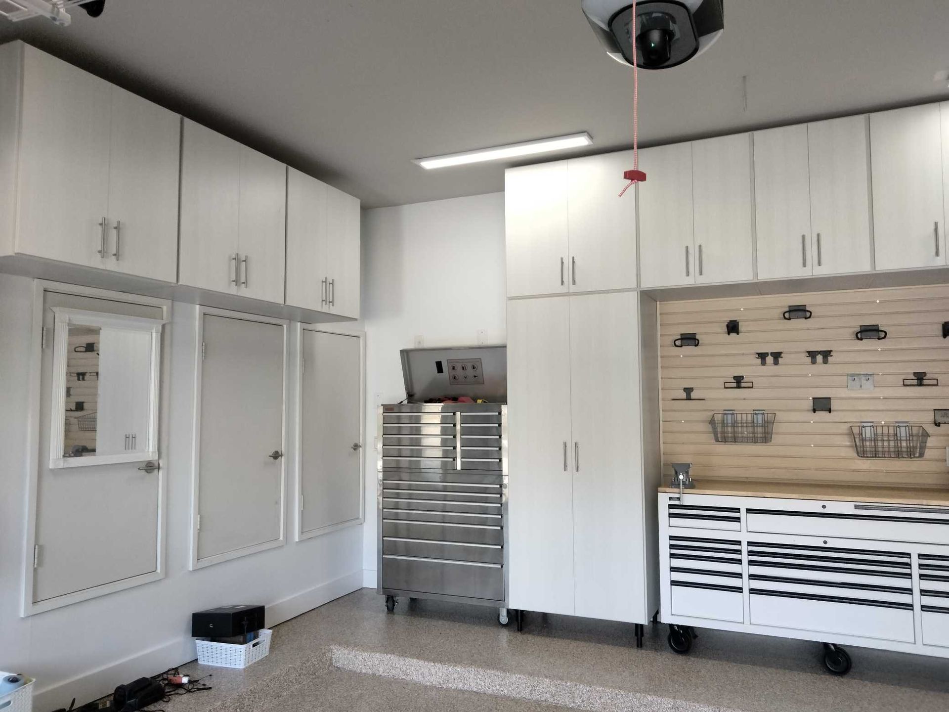A garage with white cabinets and a ceiling fan