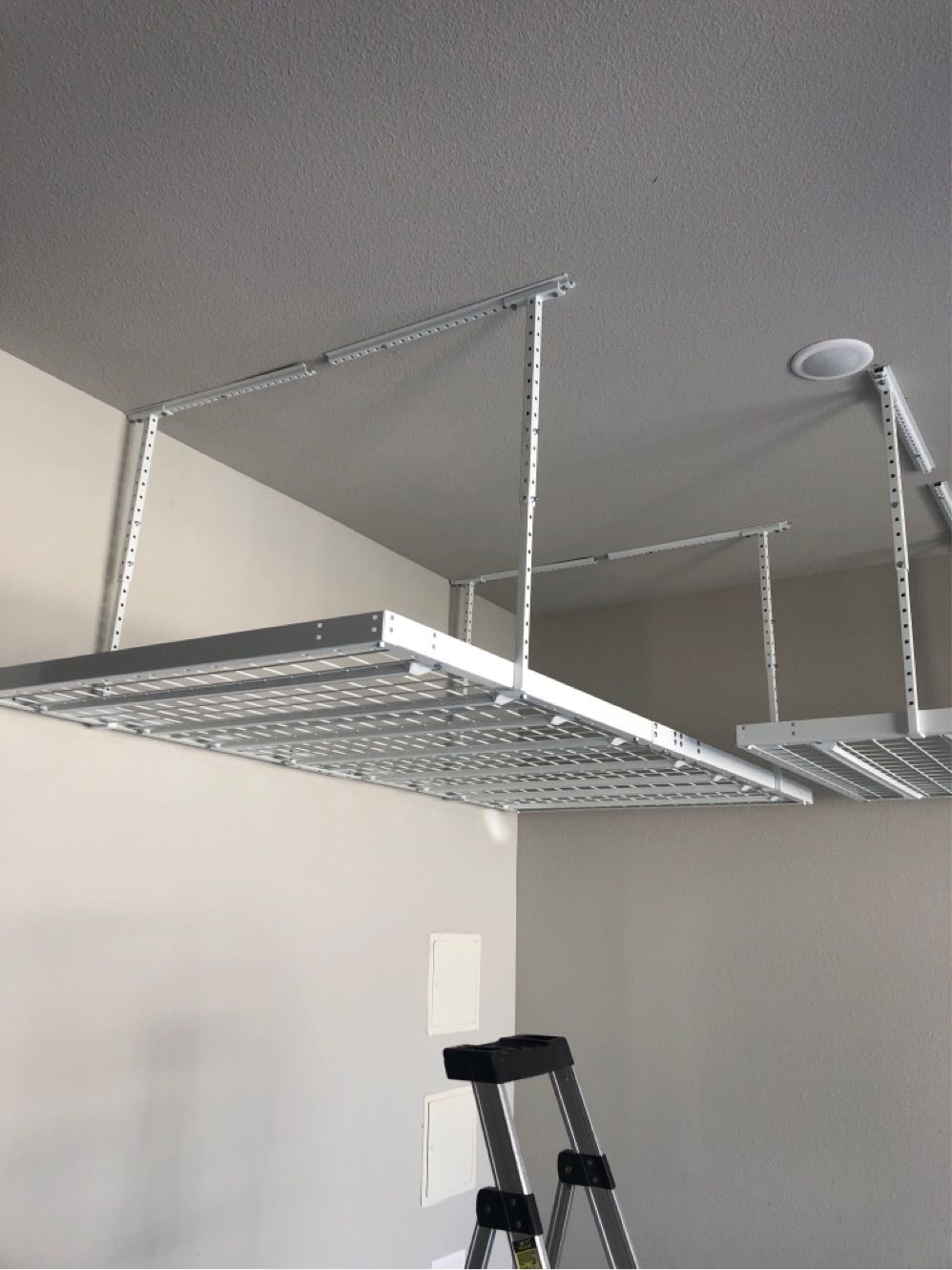 A ladder is hanging from the ceiling of a garage.
