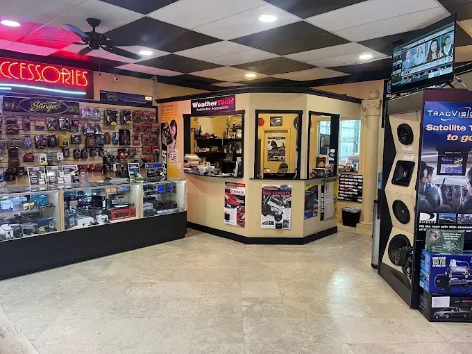 Small accessories shop interior with display cases, posters, and a checkered ceiling