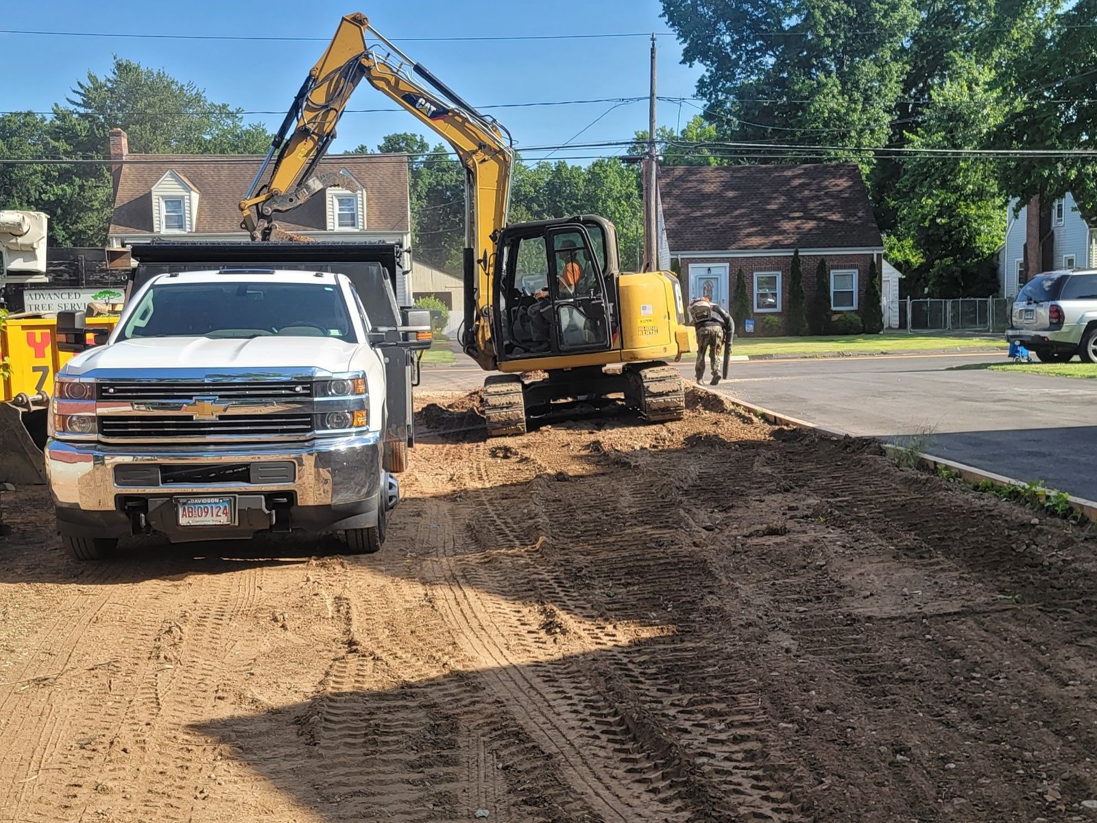 Construction site: excavator loading dump truck with dirt on a sunny day.