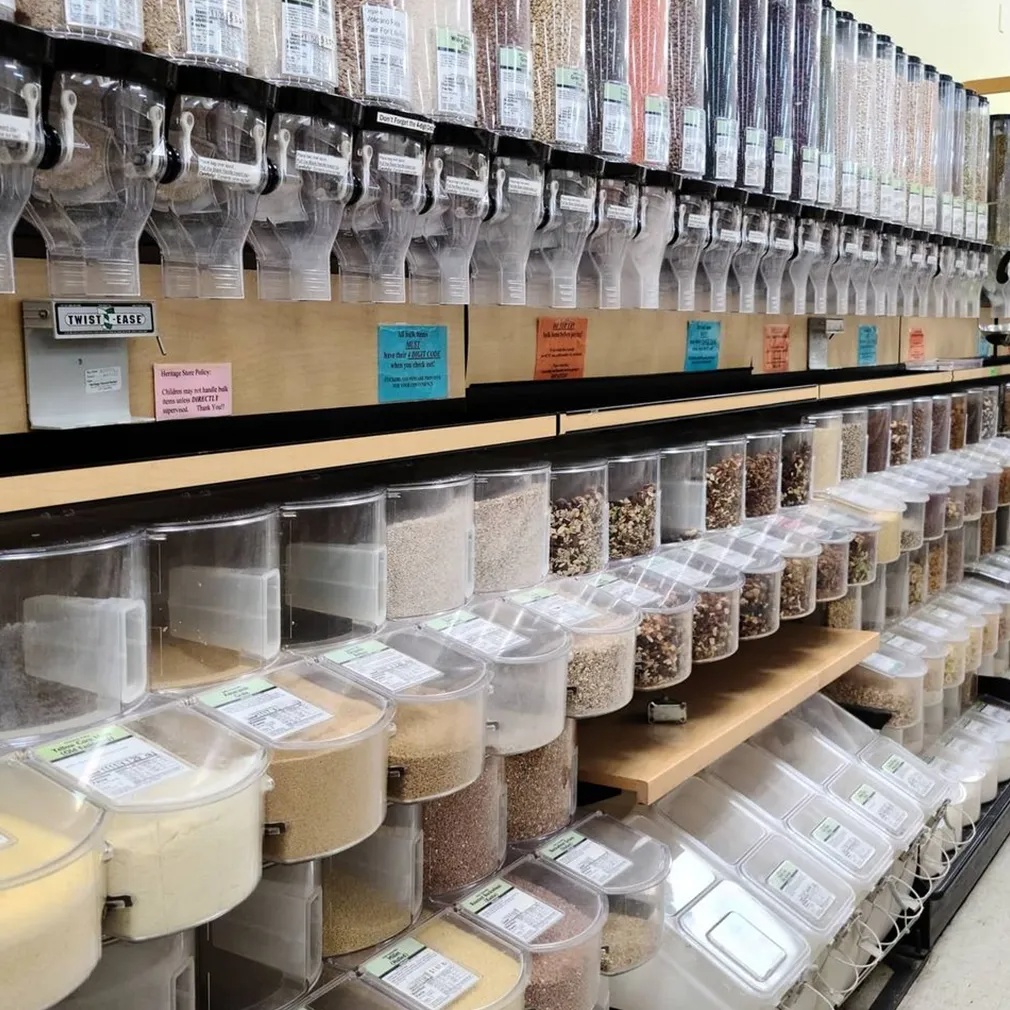 Bulk food dispensers in a store, featuring clear containers filled with grains, nuts, and other items.