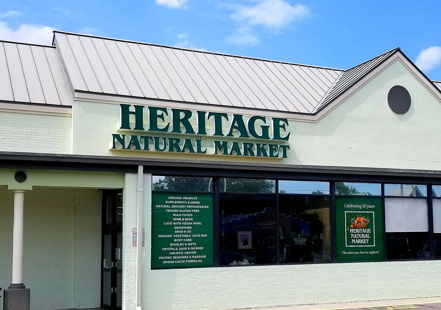 Heritage Natural Market storefront with green sign and window display.