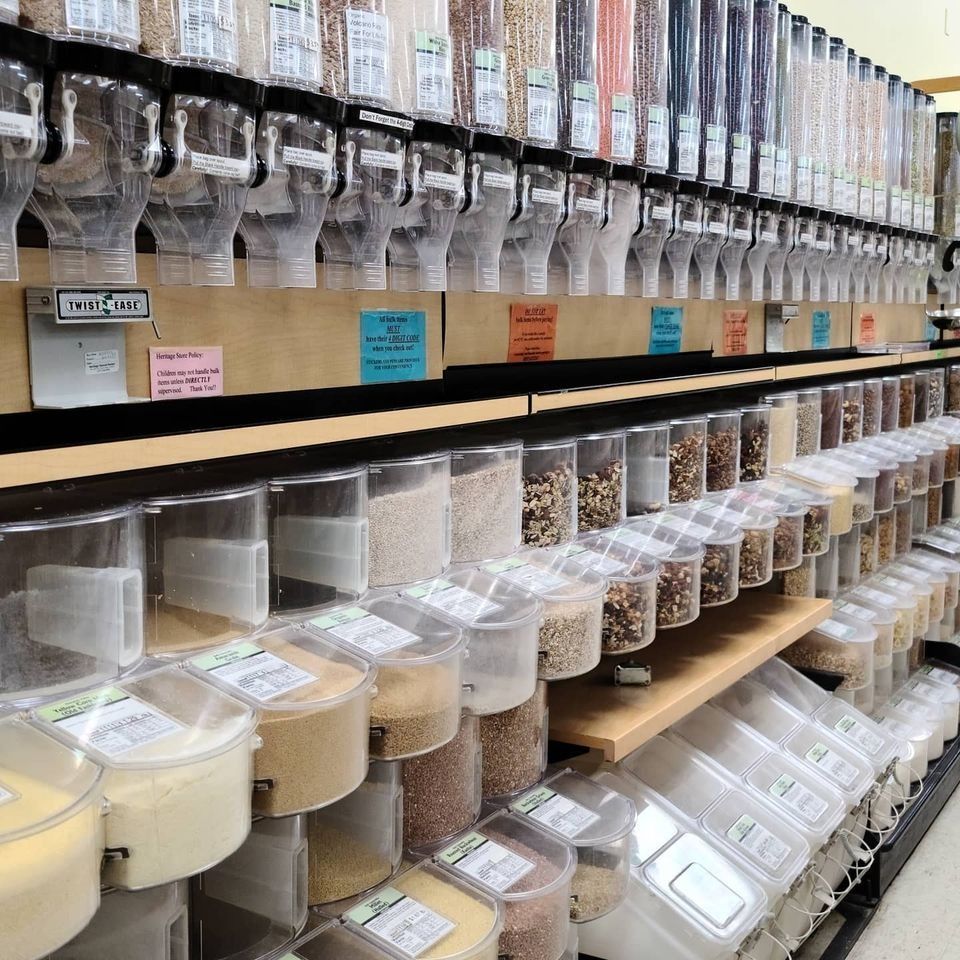 Bulk food dispensers at a grocery store, filled with grains, nuts, and seeds.