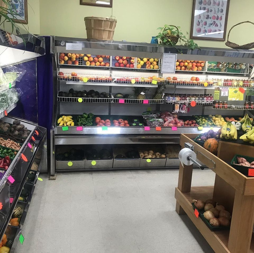 Produce displayed in refrigerated shelves at a grocery store.