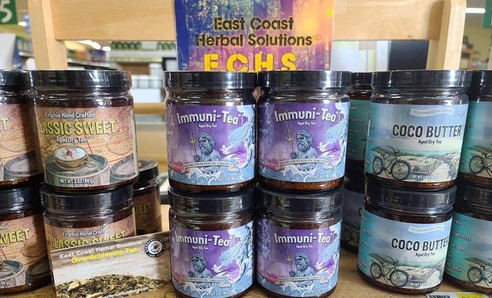 Jars of herbal tea and coco butter are on display. Sign reads 