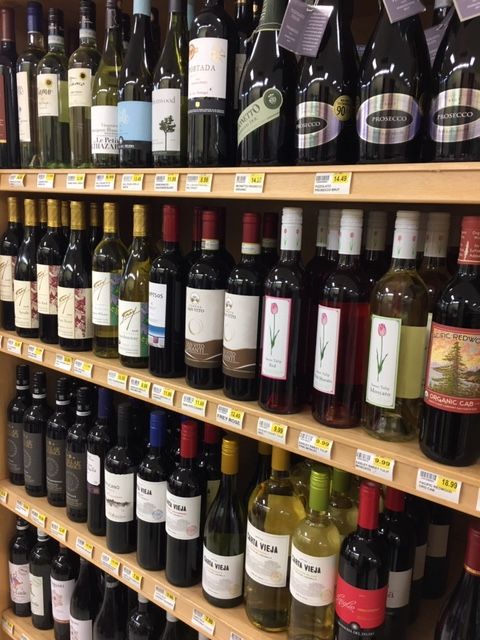 Shelves stocked with various wine bottles in a grocery store.