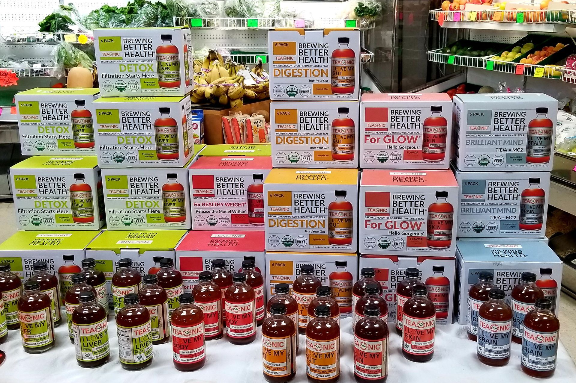 Bottles of juices on display in a store. Boxes with text: 