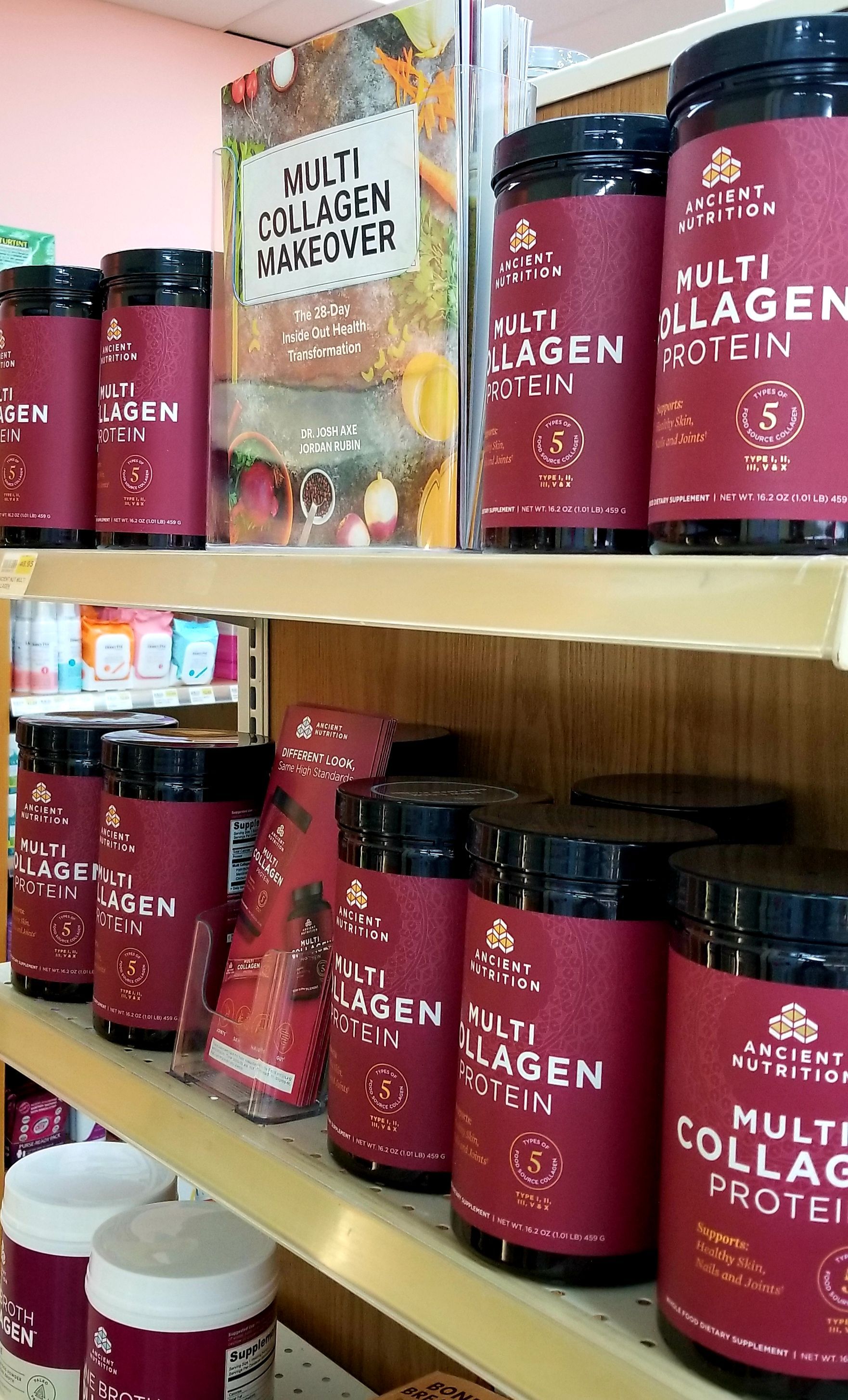 Shelves of red and black Multi Collagen Protein containers in a health food store.
