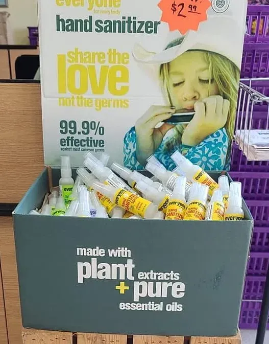 Hand sanitizer display with sign showing a girl playing harmonica; 