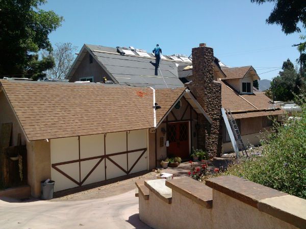 A man is working on the roof of a house