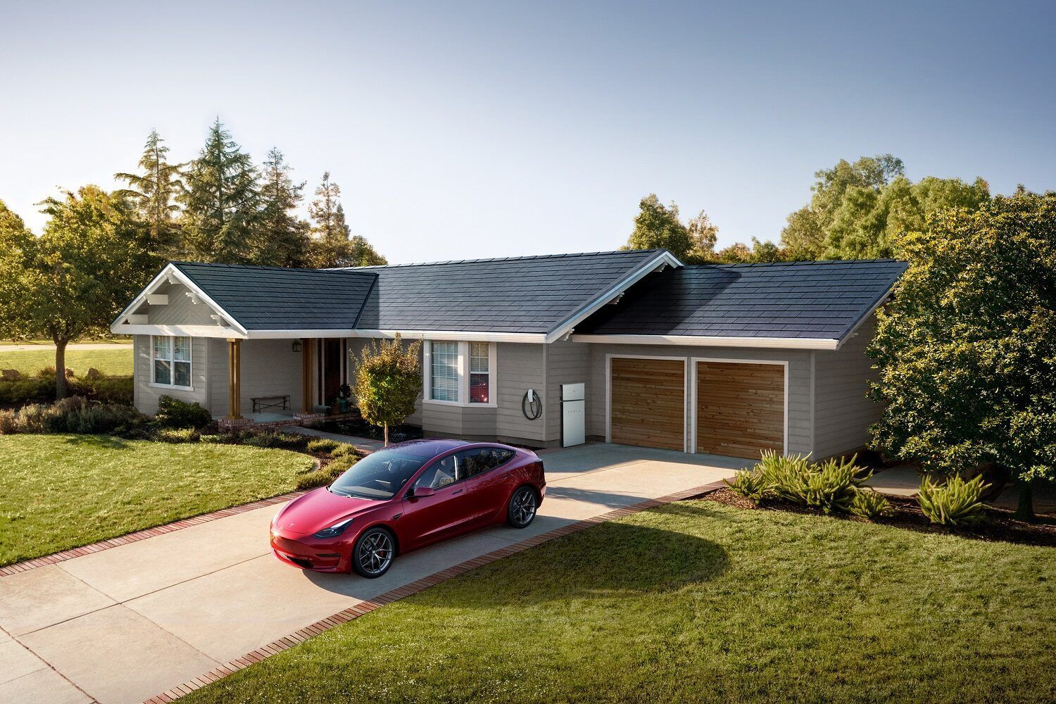A red tesla model 3 is parked in front of a house with solar panels on the roof.