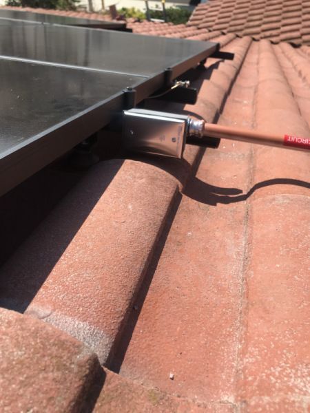 A solar panel is attached to the roof of a house