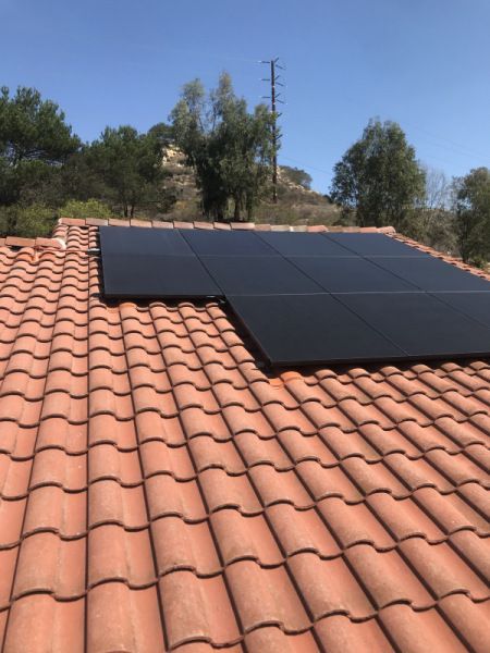A row of solar panels on a tiled roof