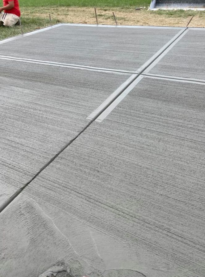 A man is kneeling down on a concrete floor.
