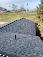 The roof of a house with a water tower in the background.