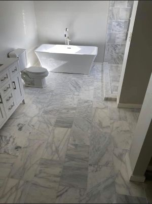 A bathroom with a tub , toilet , and vanity.