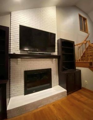 A living room with a fireplace and a flat screen tv.