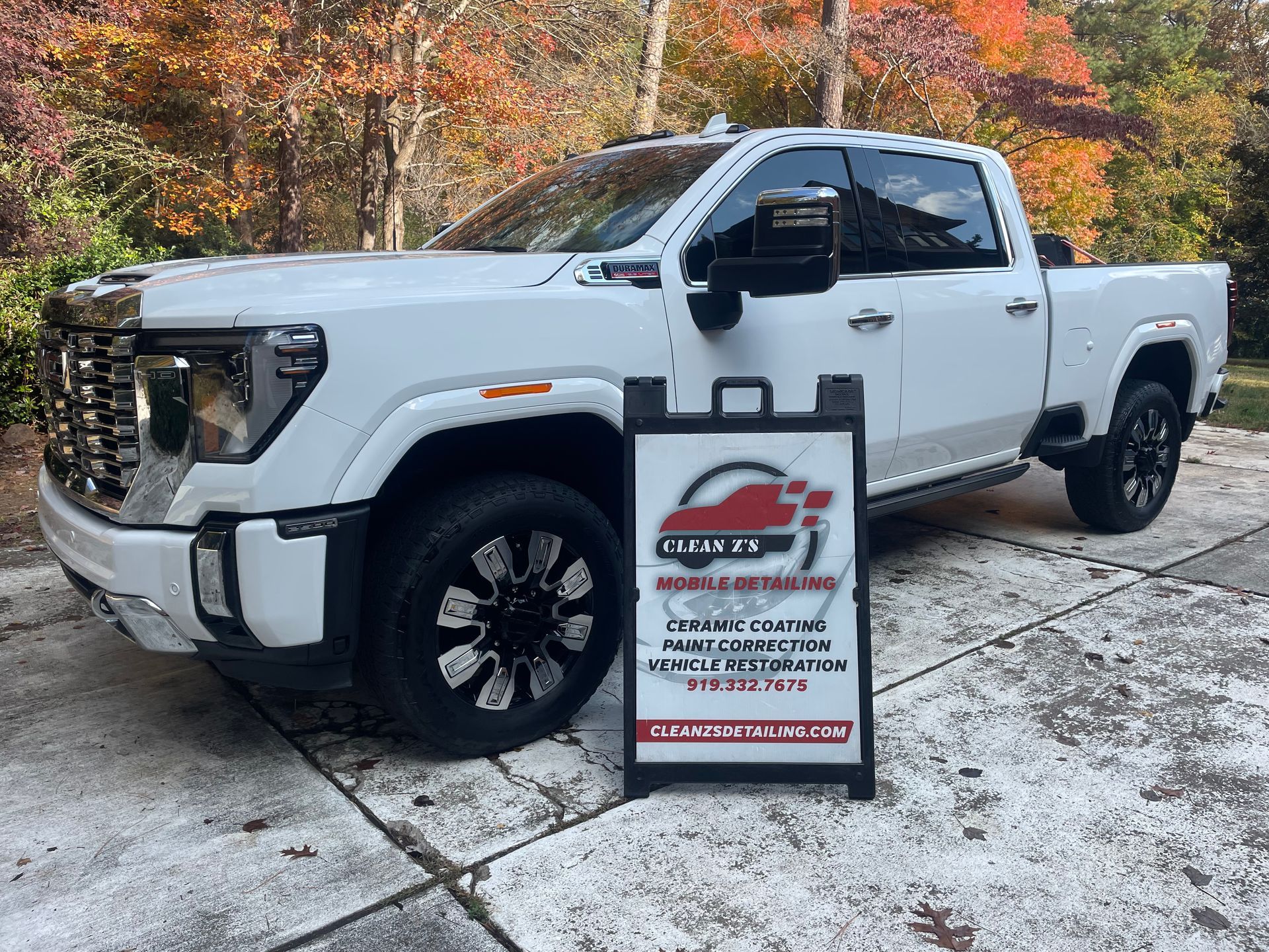 White pickup truck with business sign in front.