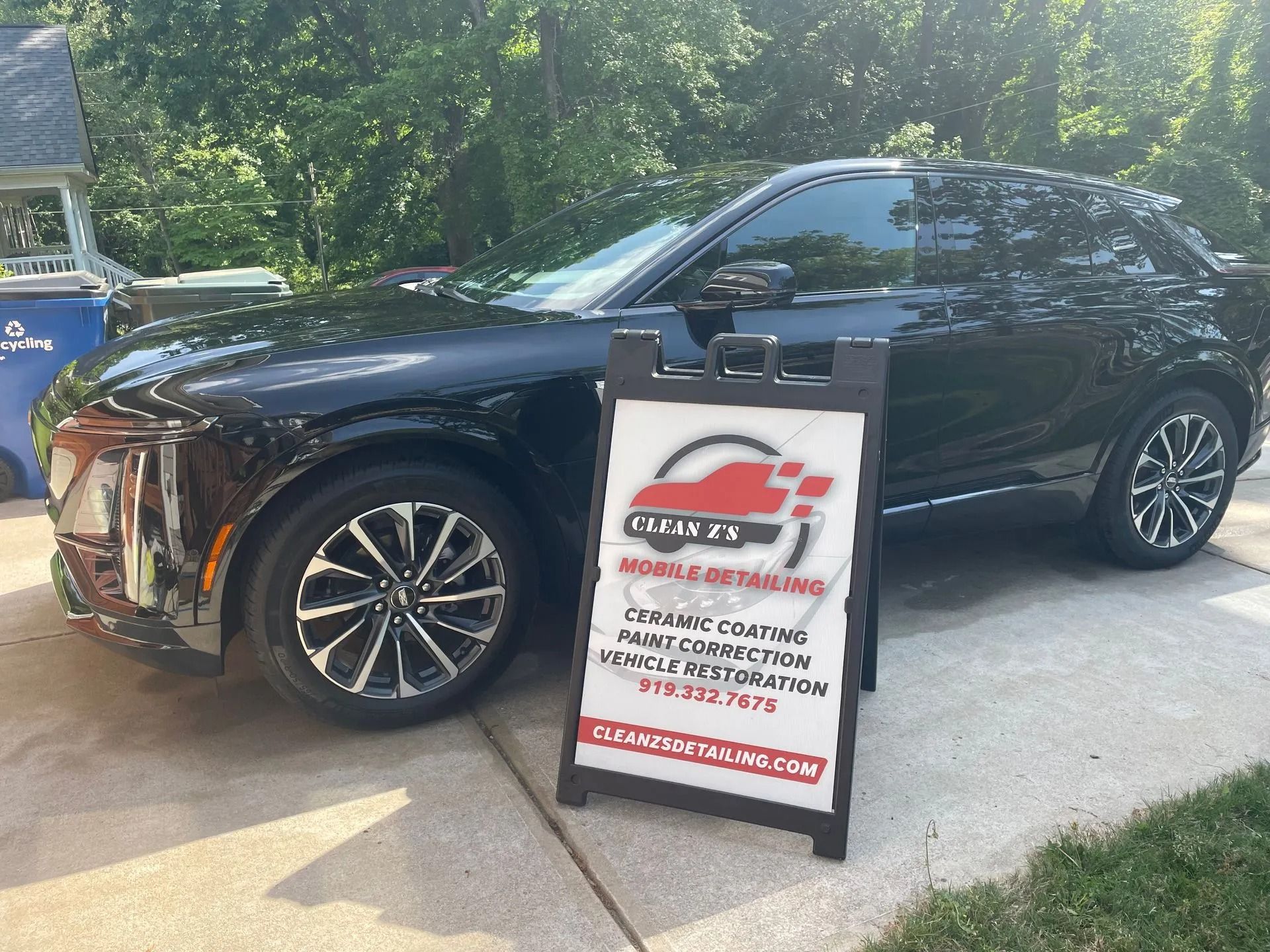 Black car with mobile detailing sign.