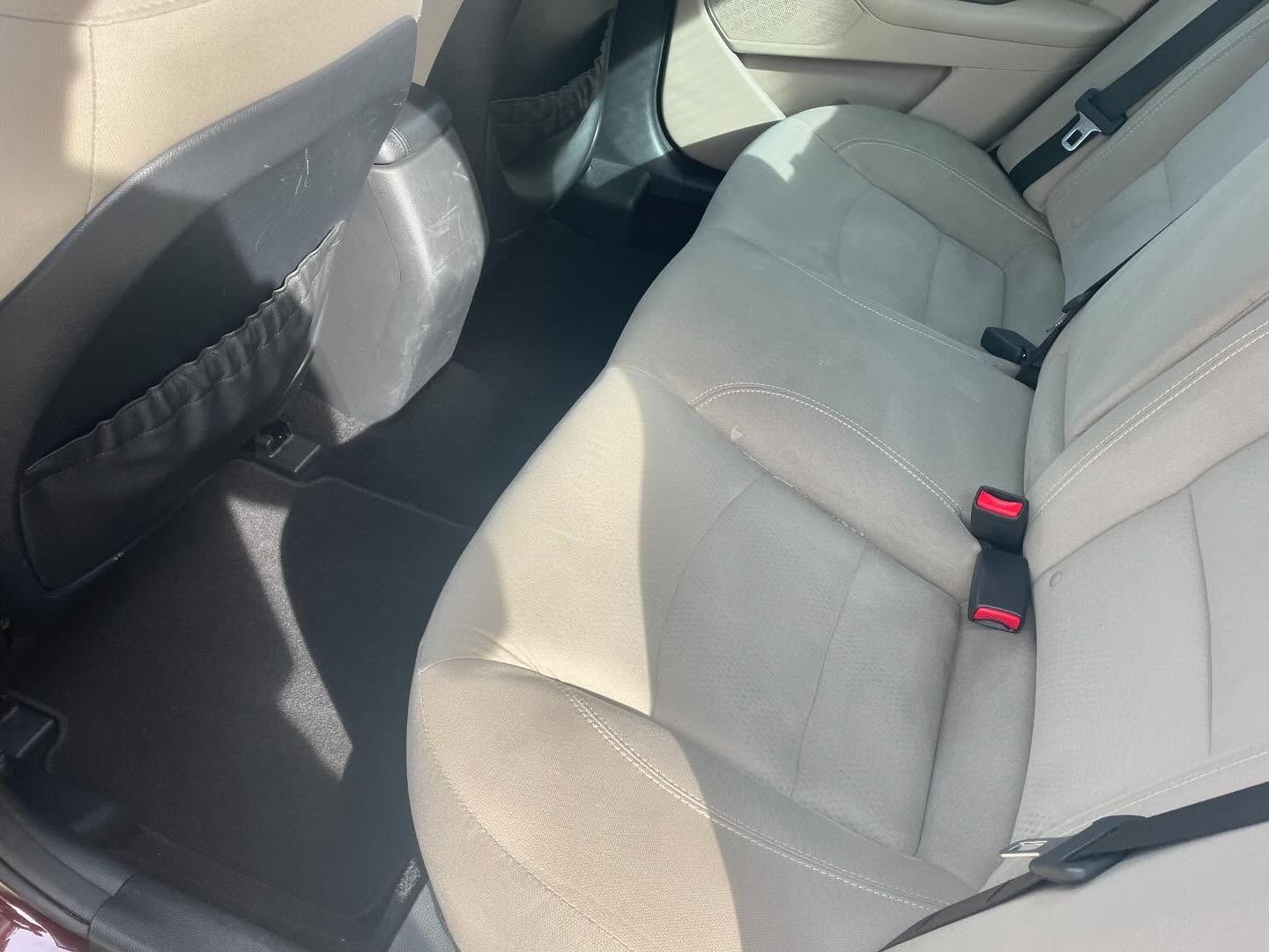 Beige car back seat with a black floor and storage pocket.
