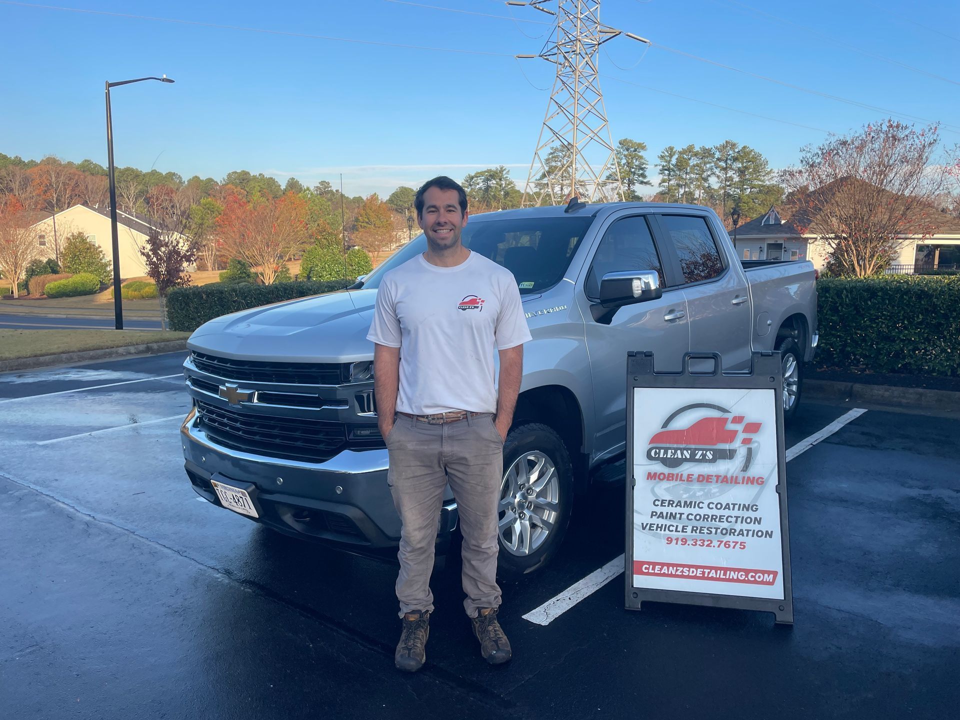Man standing next to a silver pickup truck.