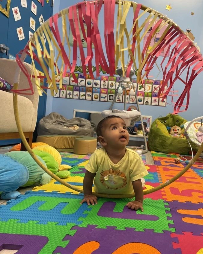 A baby is playing with a hula hoop in a room