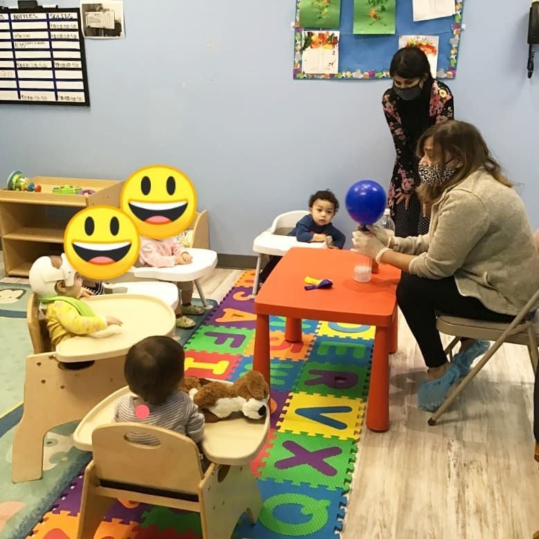 A group of children are playing in a room with smiley faces on the walls