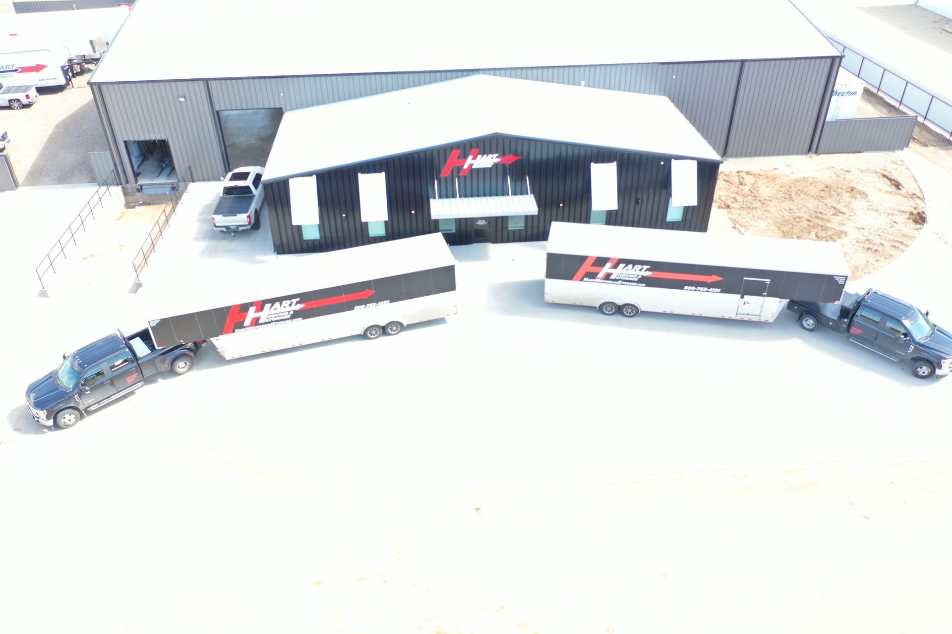 Aerial view of H&S Motorsports building and two semi-trucks with trailers parked in front.
