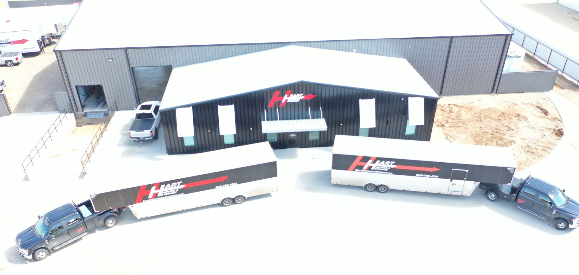 Aerial view of H&S Motorsports building and two semi-trucks with trailers parked in front.