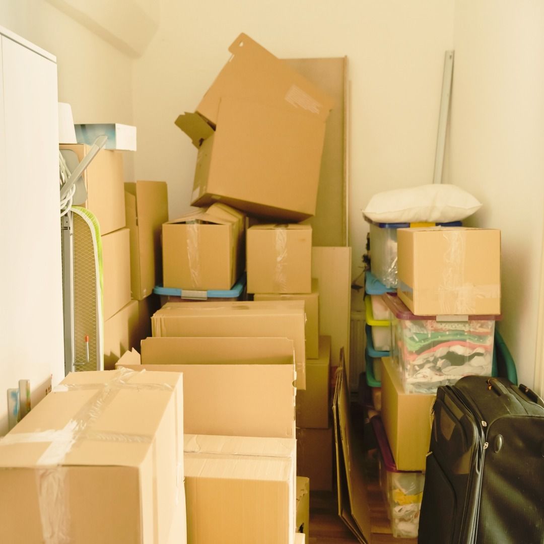 Boxes piled in a small storage space, ready for a move or storage.