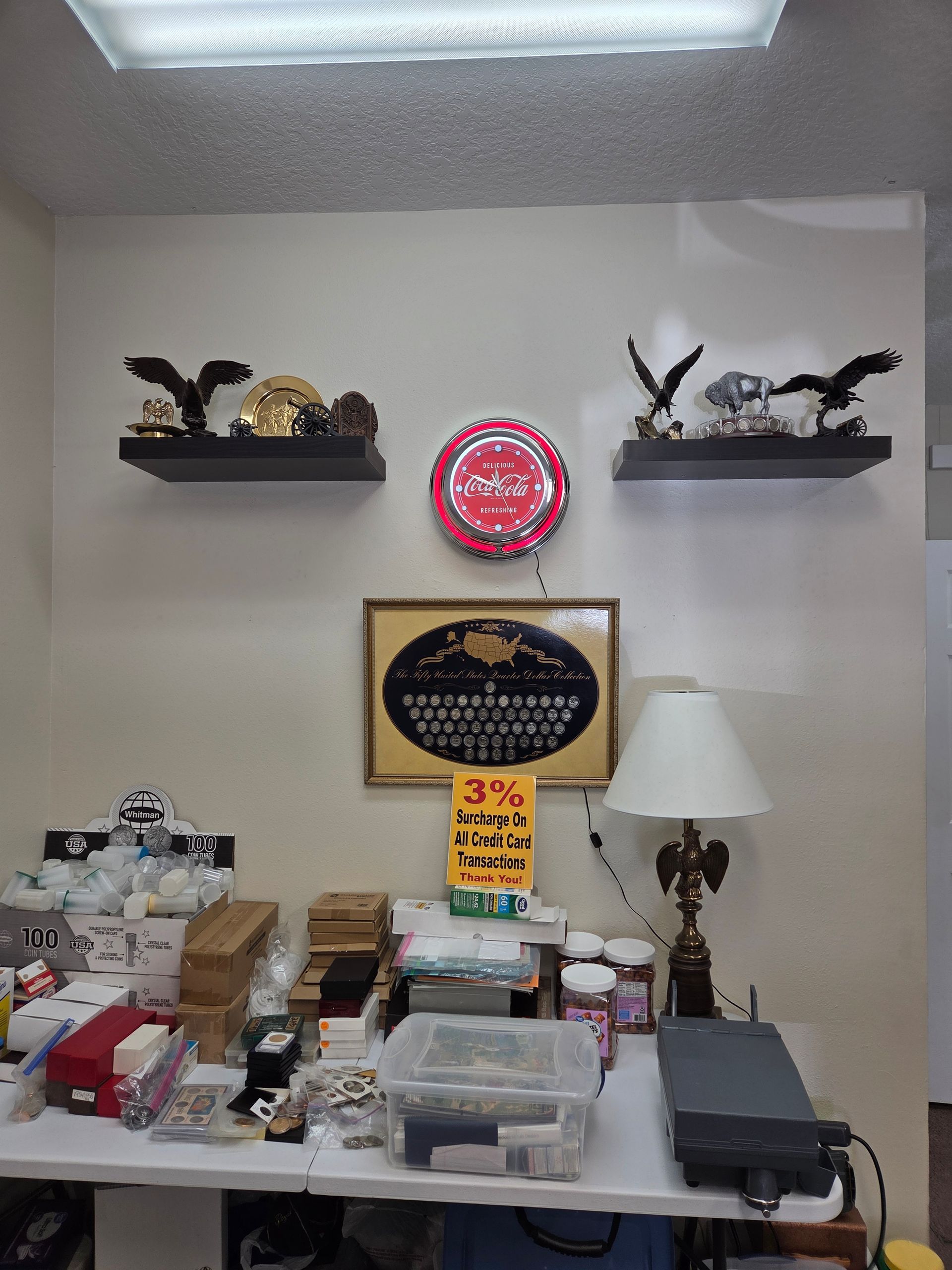 Shelf with eagle figurines, desk with items, framed plaque, lamp, and a red and white balloon.