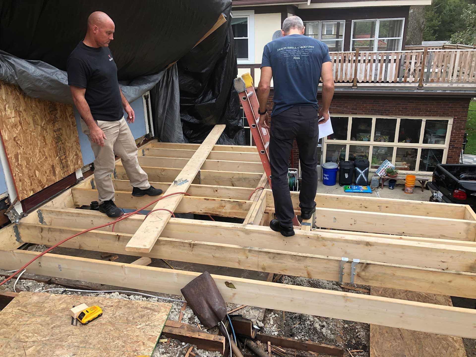 Two men standing on top of new floor foundation