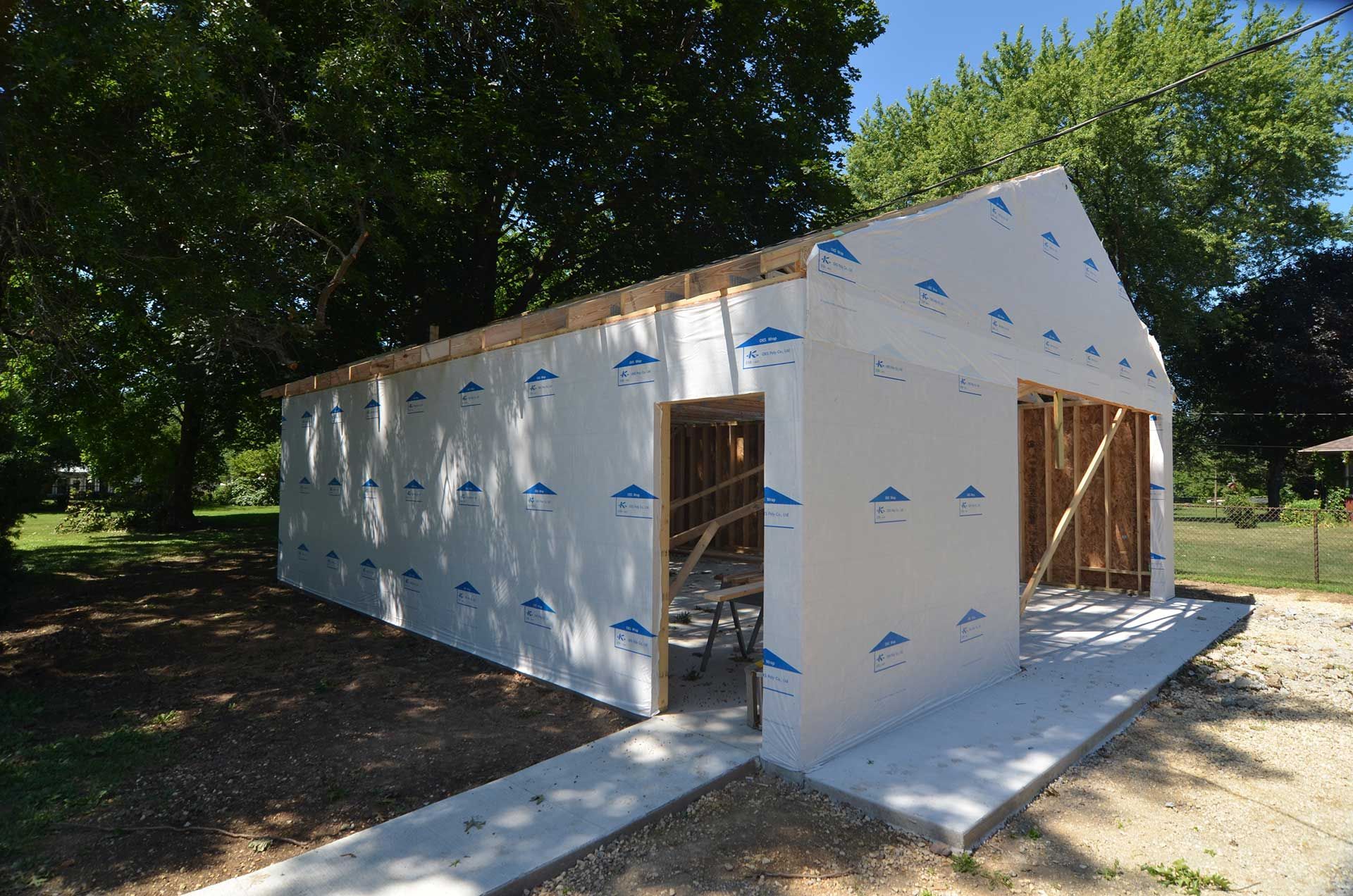 Side view of garage covered in house wrap