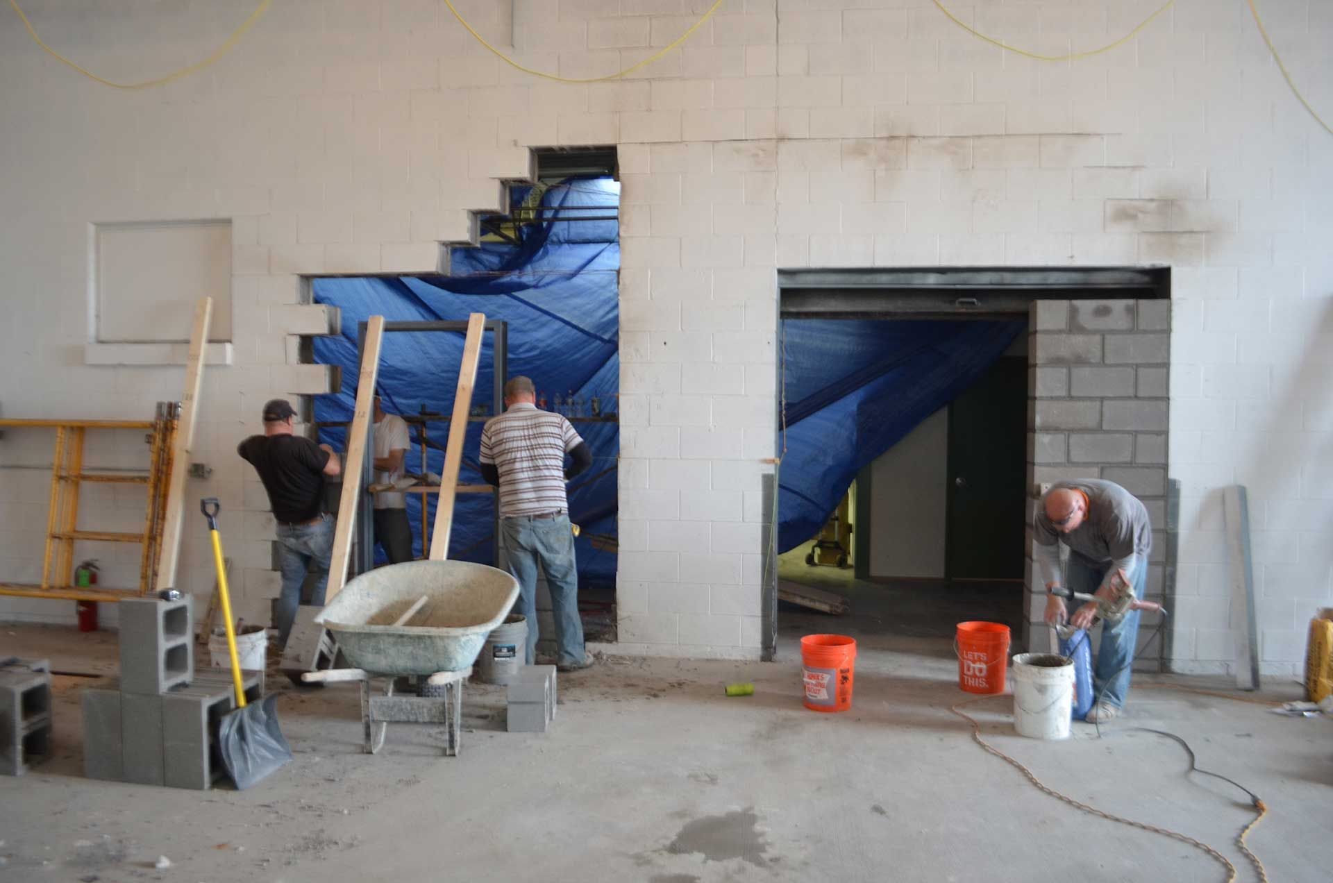 Workers creating a whole on the wall