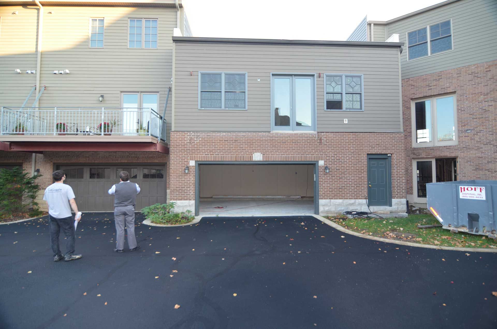 Two men inspecting the exterior of a house