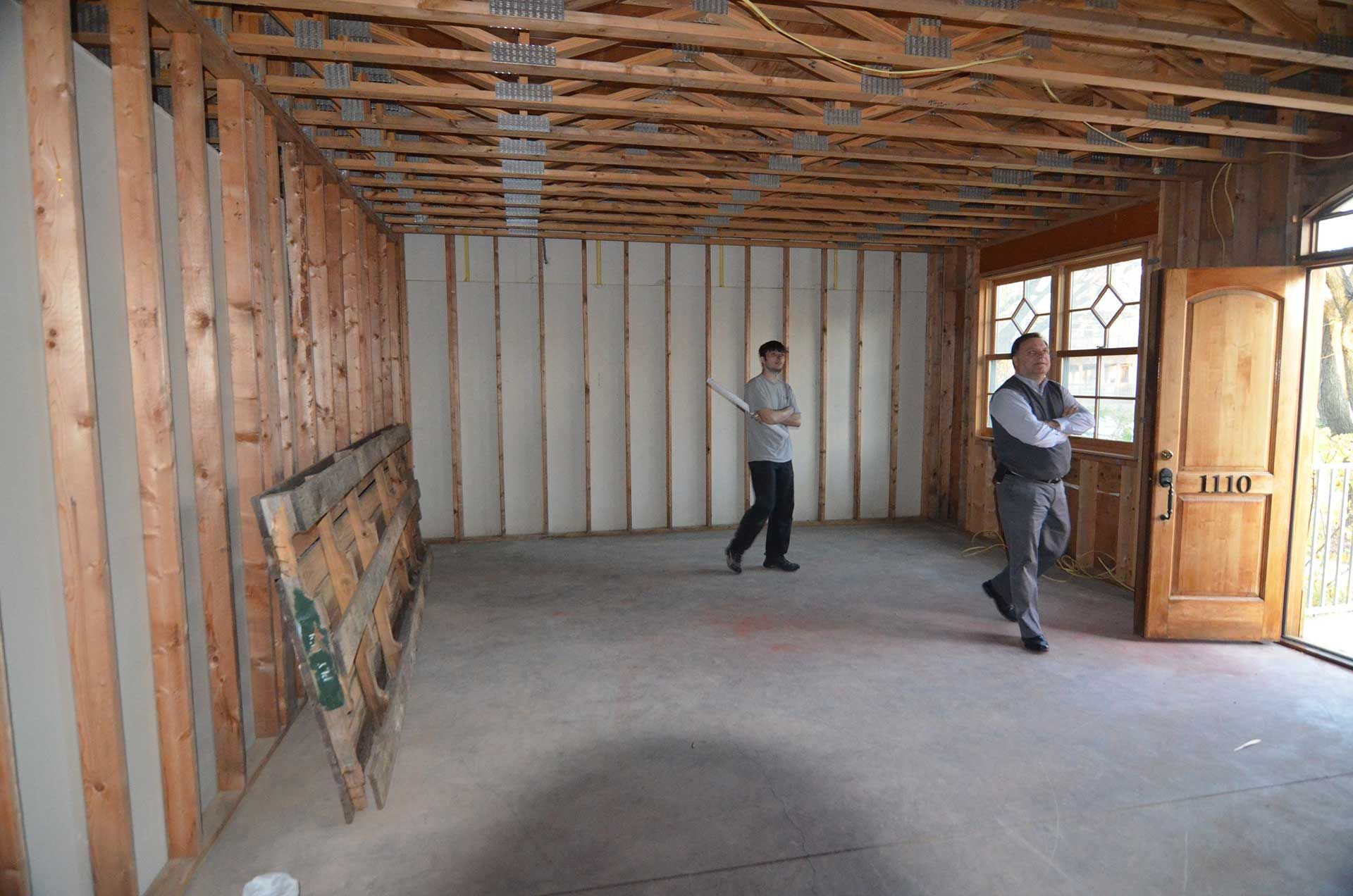 Two men walking inside house under construction