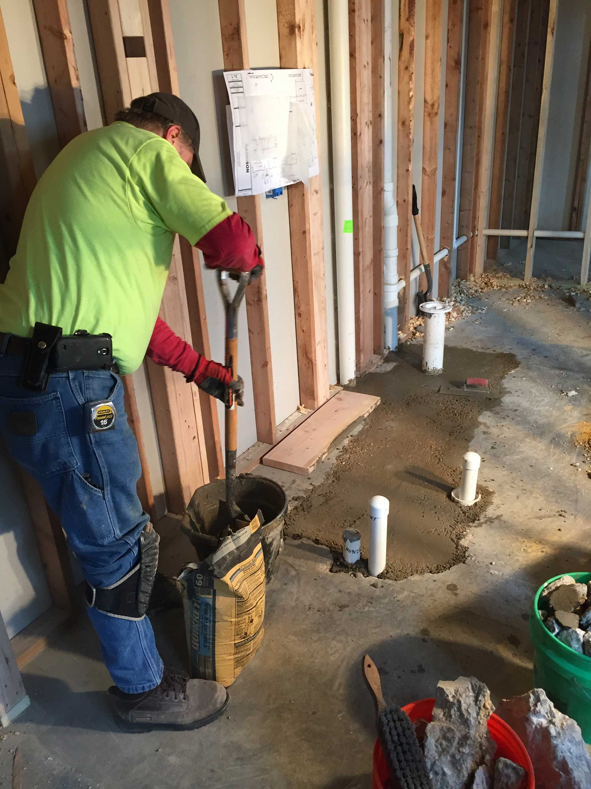Man pouring cement for the pipes