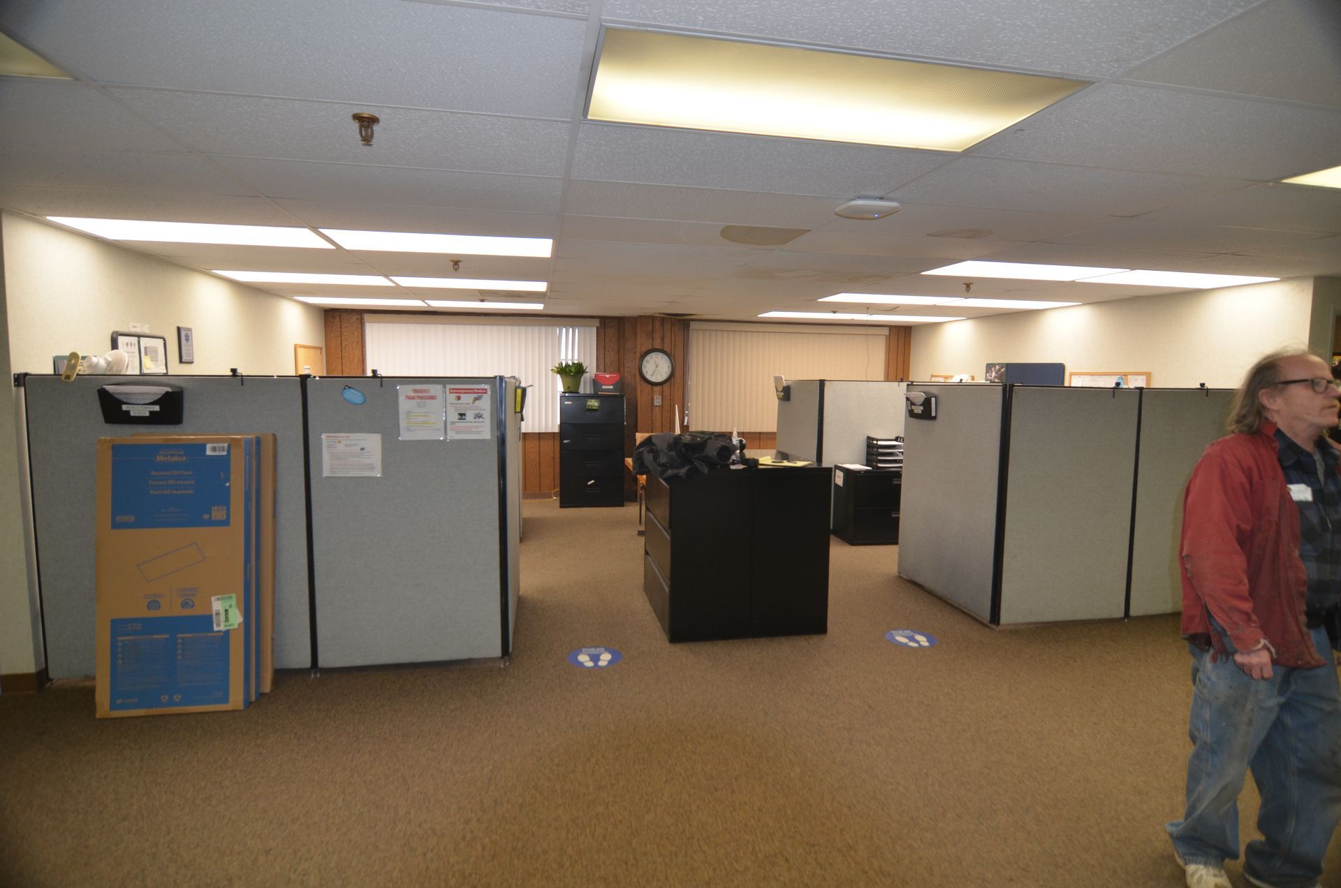 An empty office with cubicles and a cardboard box on the floor