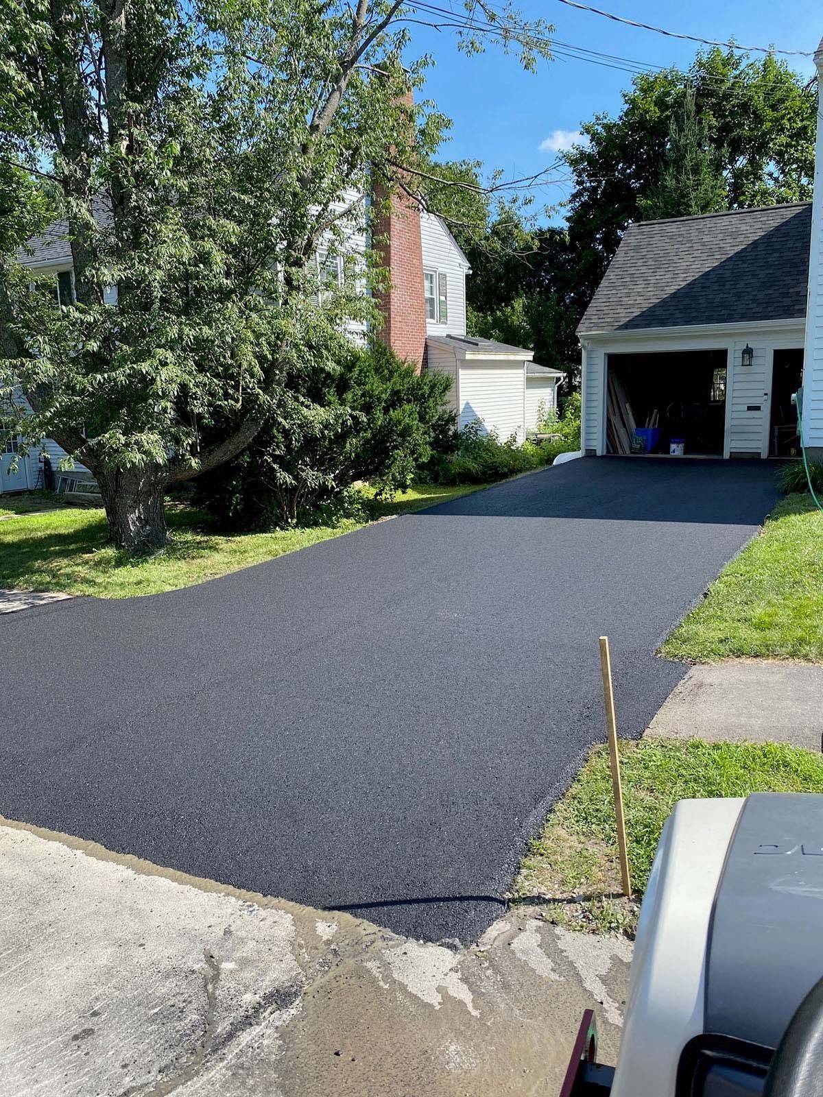 A driveway is being paved in front of a house