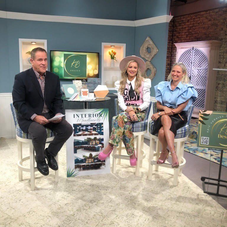 Three people are sitting in front of a sign that says interior