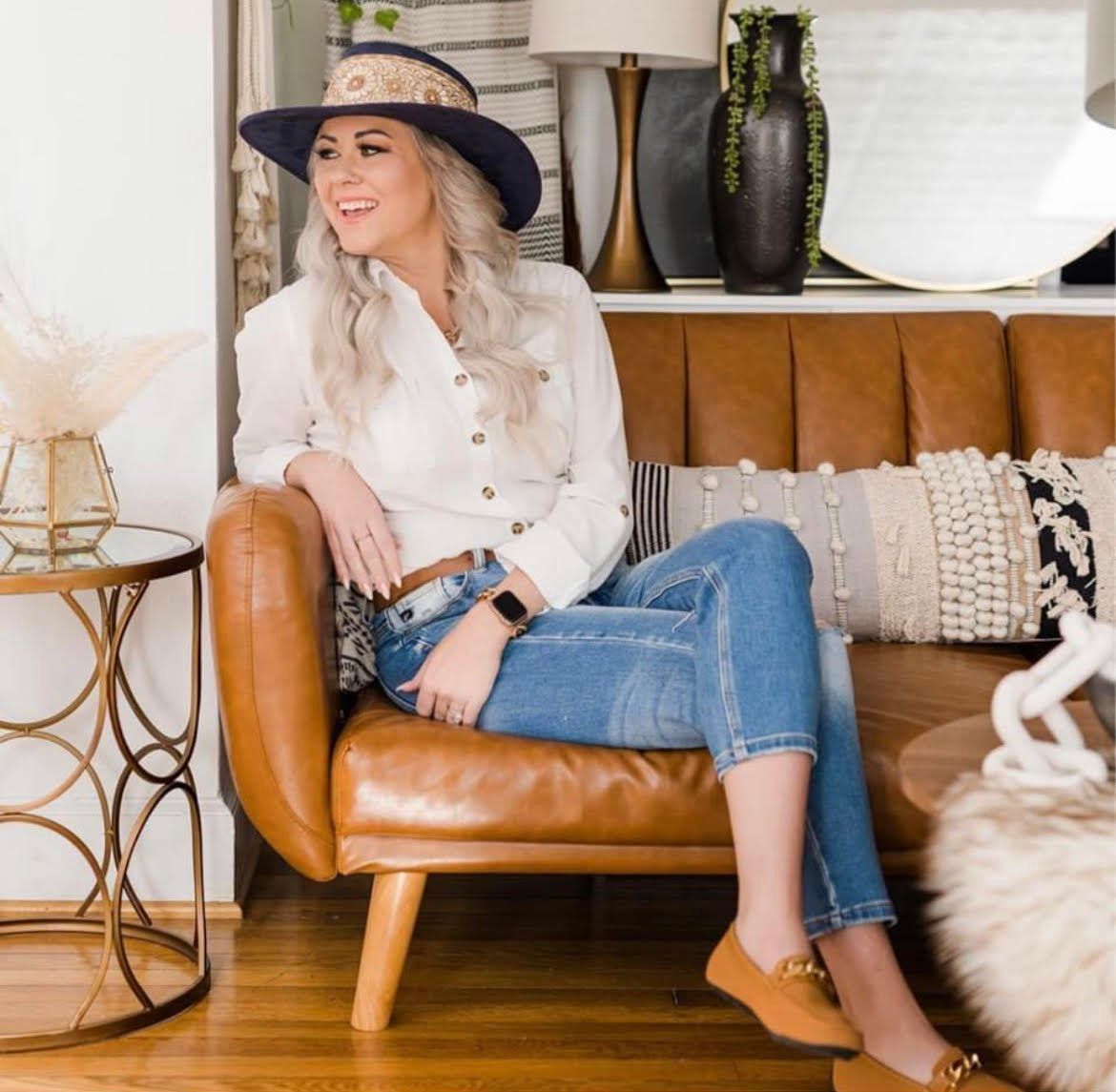 A woman wearing a hat is sitting in a chair